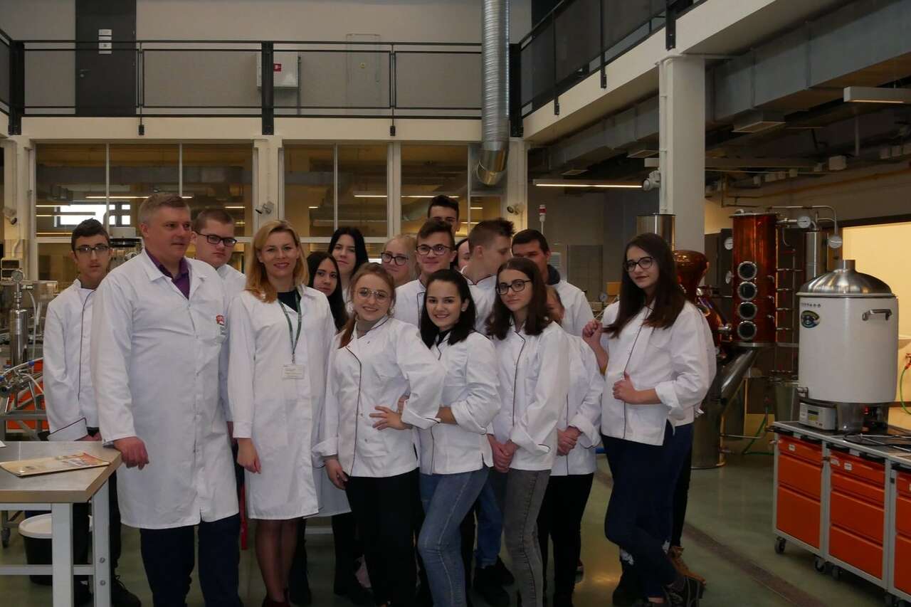 Grupa osób ubrana w białe fartuchy laboratoryjne